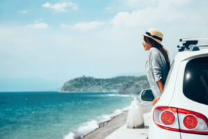 woman looking out of car at the ocean