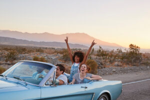 friends celebrating in convertible car