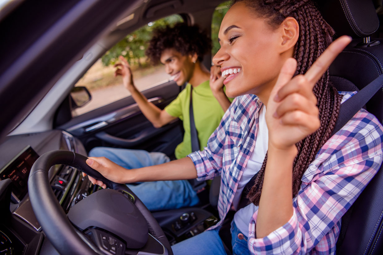 Woman Turning Up The Volume On The Car Radio Stock Photo