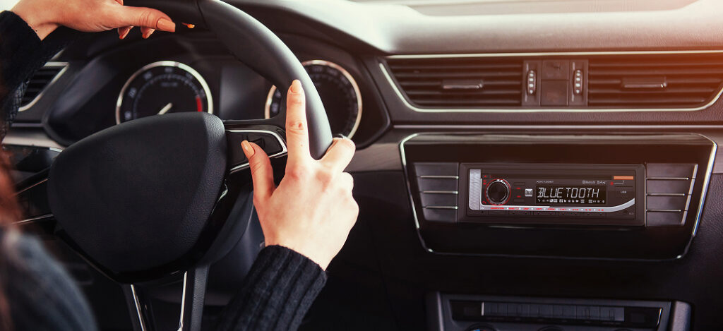 XDC100BT car stereo mounted in dash with woman driving