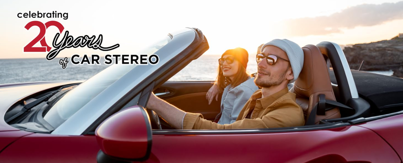 couple in red convertible car with slogan celebrating 20 years in car audio